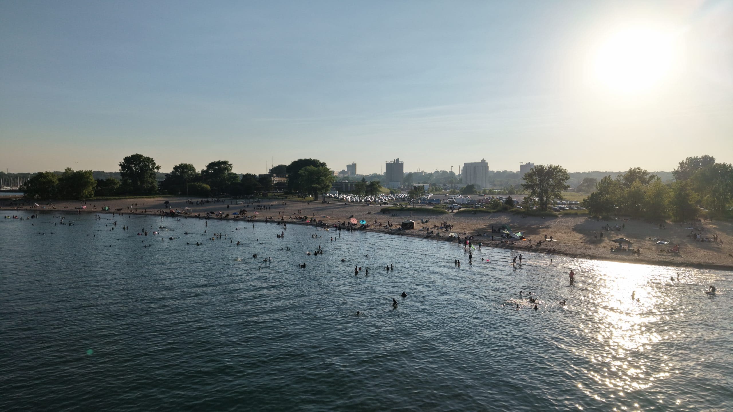 People enjoying Waukegan Municipal Beach on Lake Michigan at sunset.