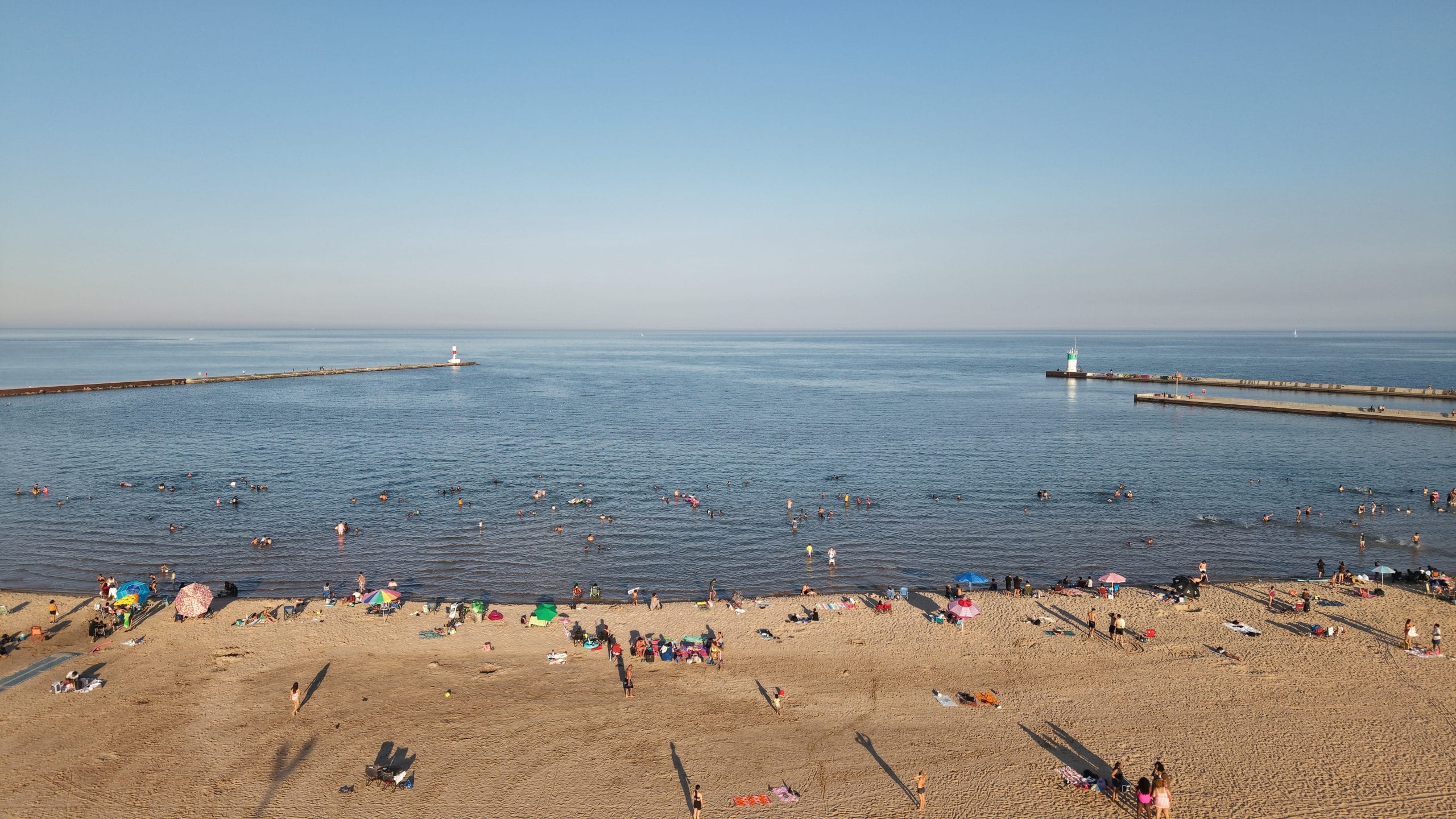 People enjoying the sandy beach at Waukegan Municipal Beach, Lake Michigan shoreline, IL.