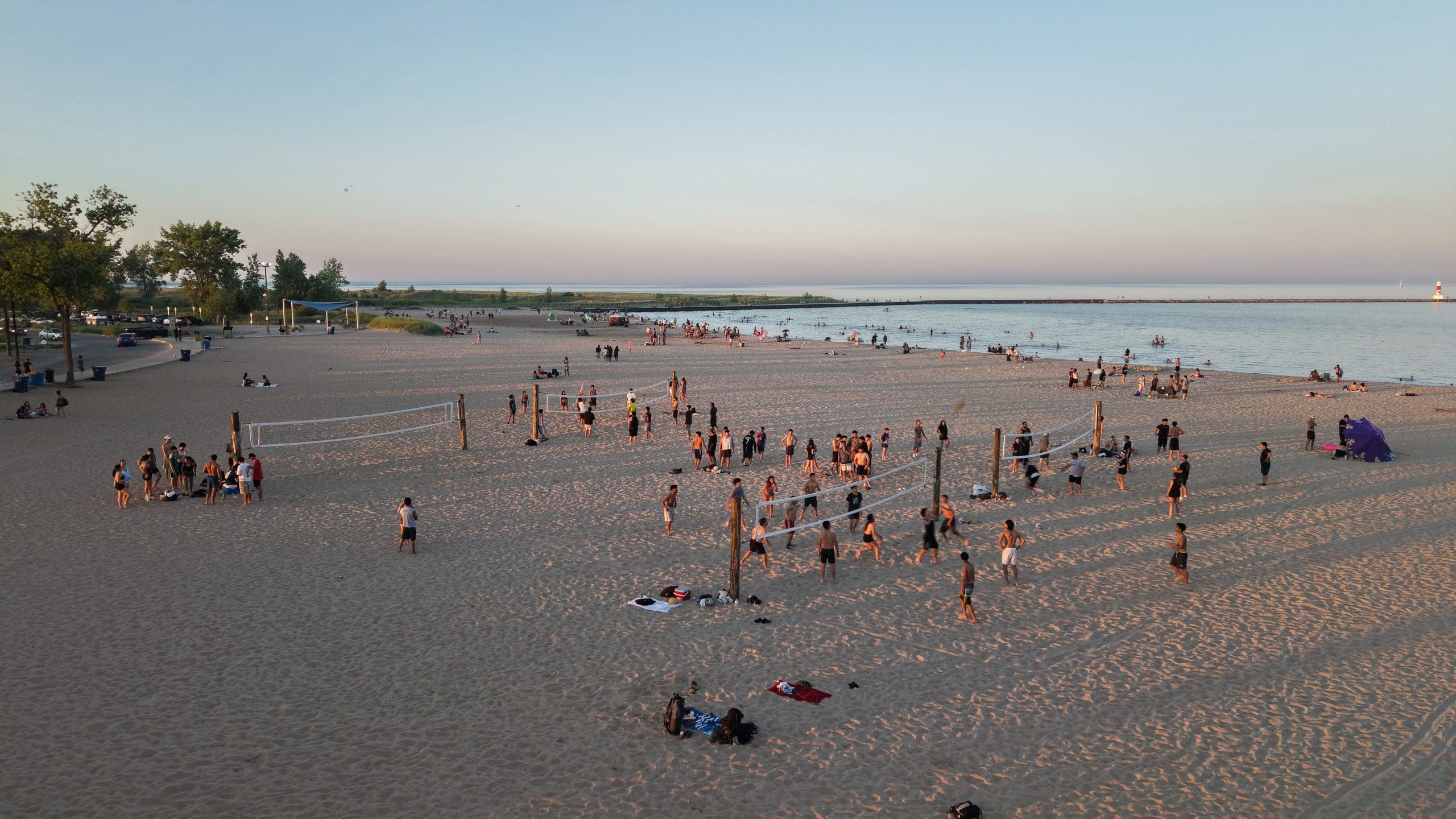 People enjoying the beach at Waukegan on Lake Michigan at sunset.