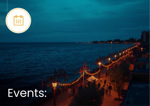 Waukegan Lake Michigan shoreline with festive string lights and people walking.