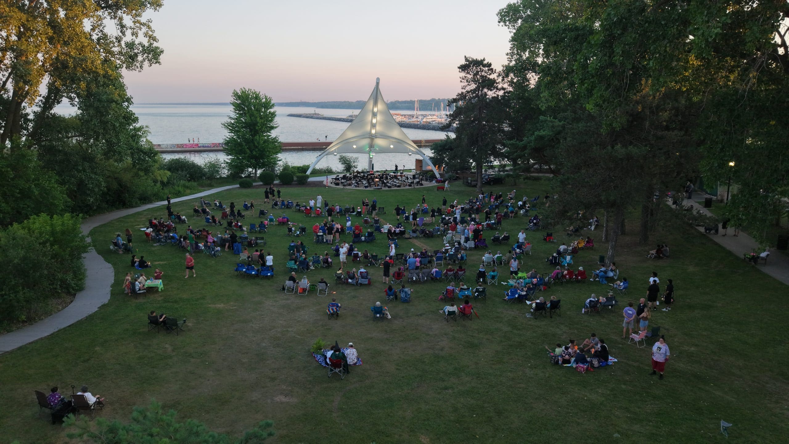 People enjoying outdoor concert at Waukegan Lakefront Park near Lake Michigan.