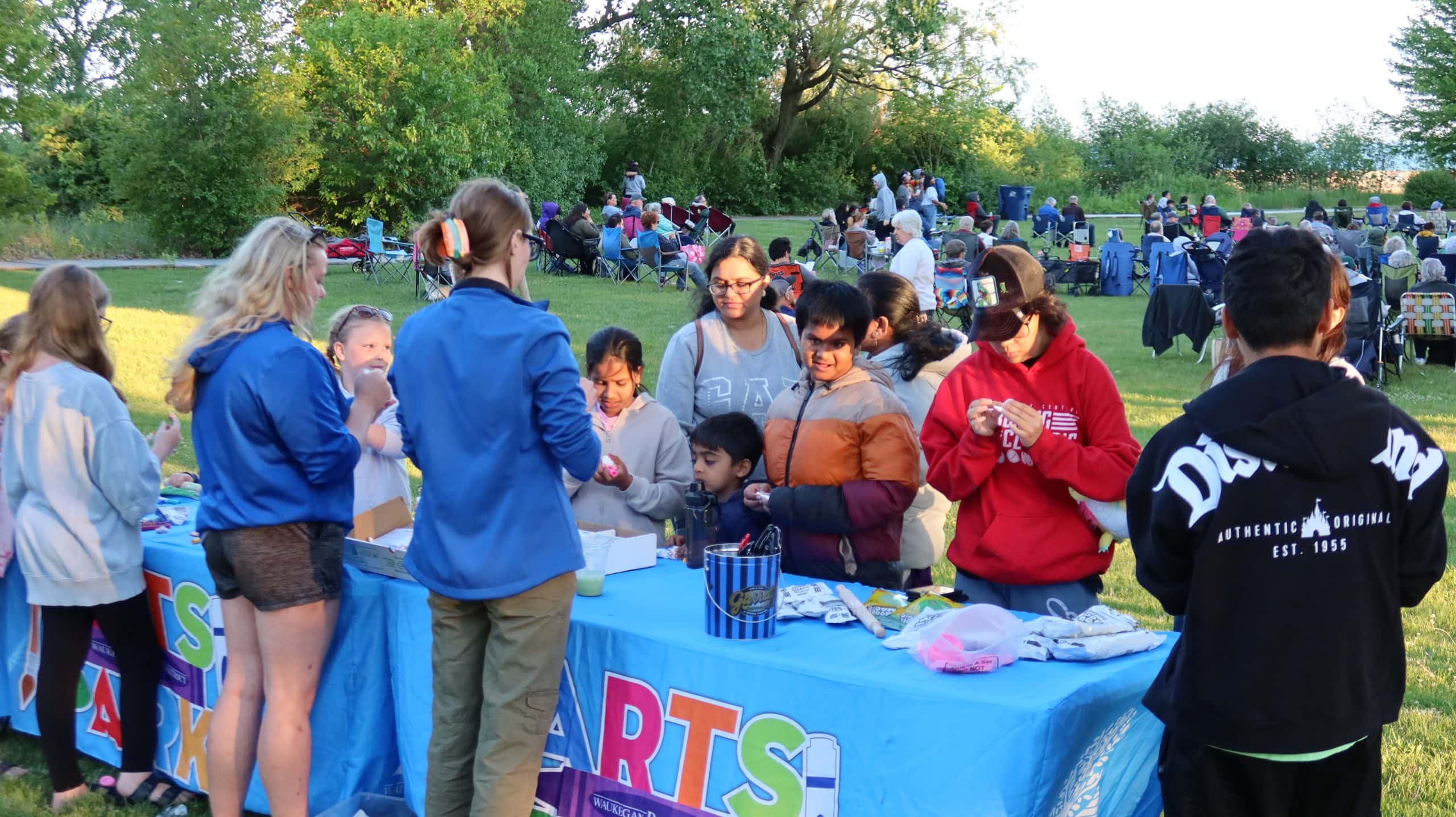 People enjoying a community arts festival in Waukegan's park near Lake Michigan.