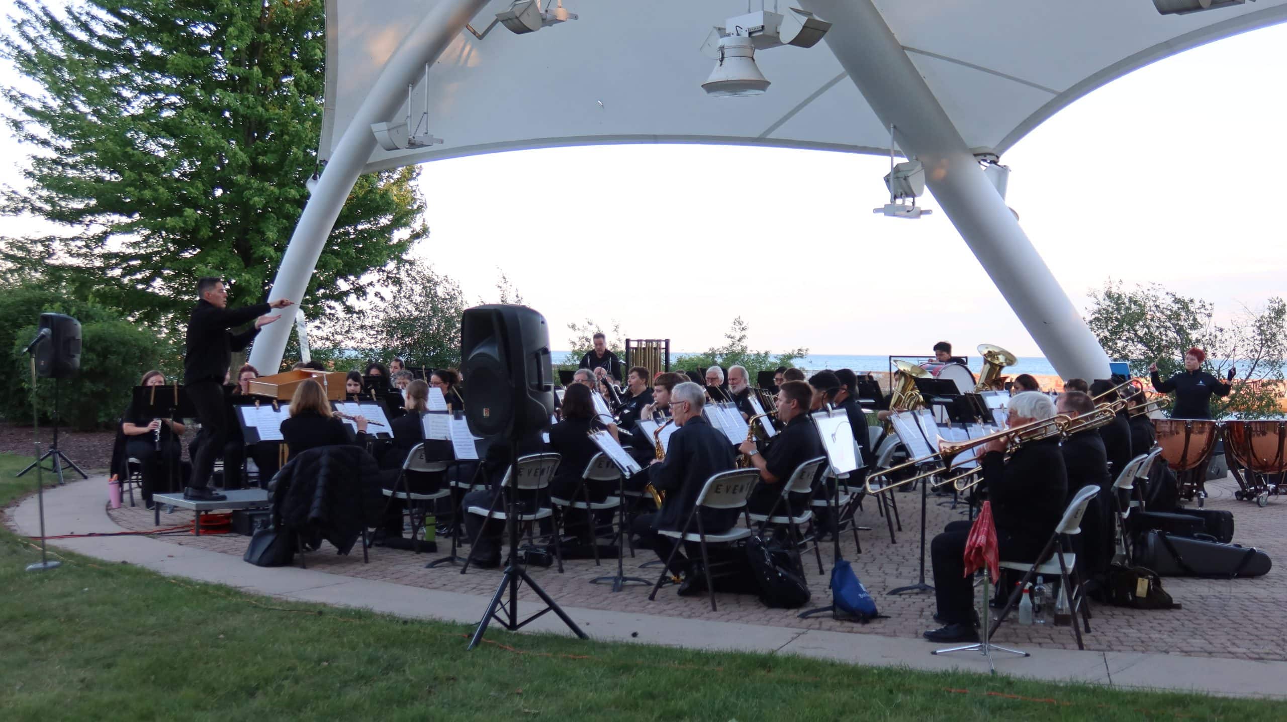 Orchestra performing outdoors at Waukegan park near Lake Michigan.