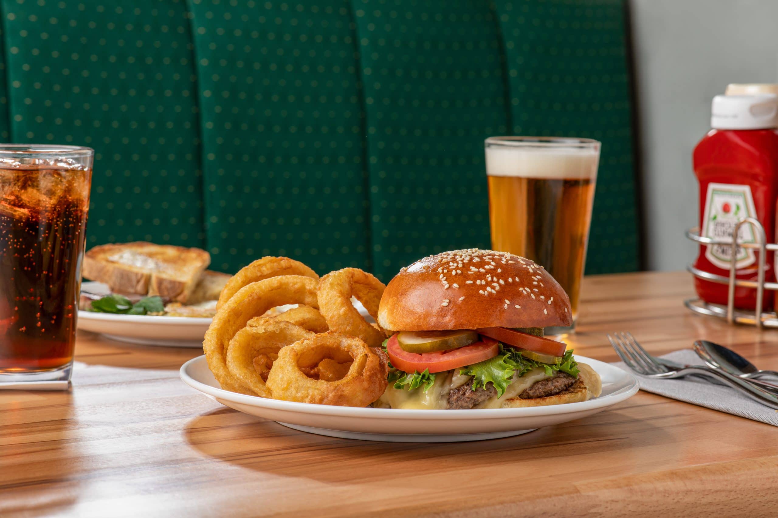 Juicy burger with onion rings, fries, and drinks at a Waukegan restaurant.