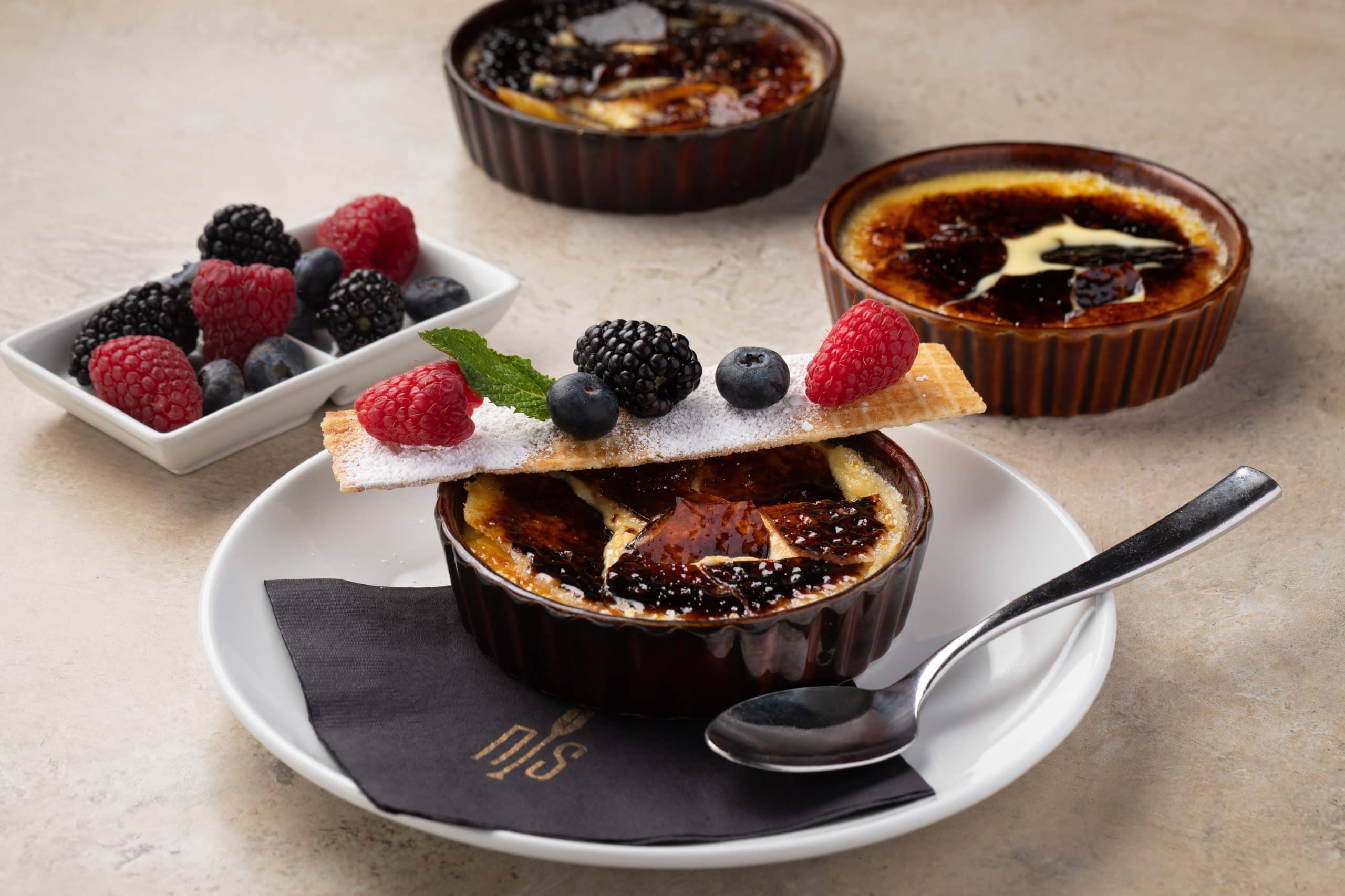 Crème brûlée desserts with berries at Northshore Steaks in Waukegan IL.
