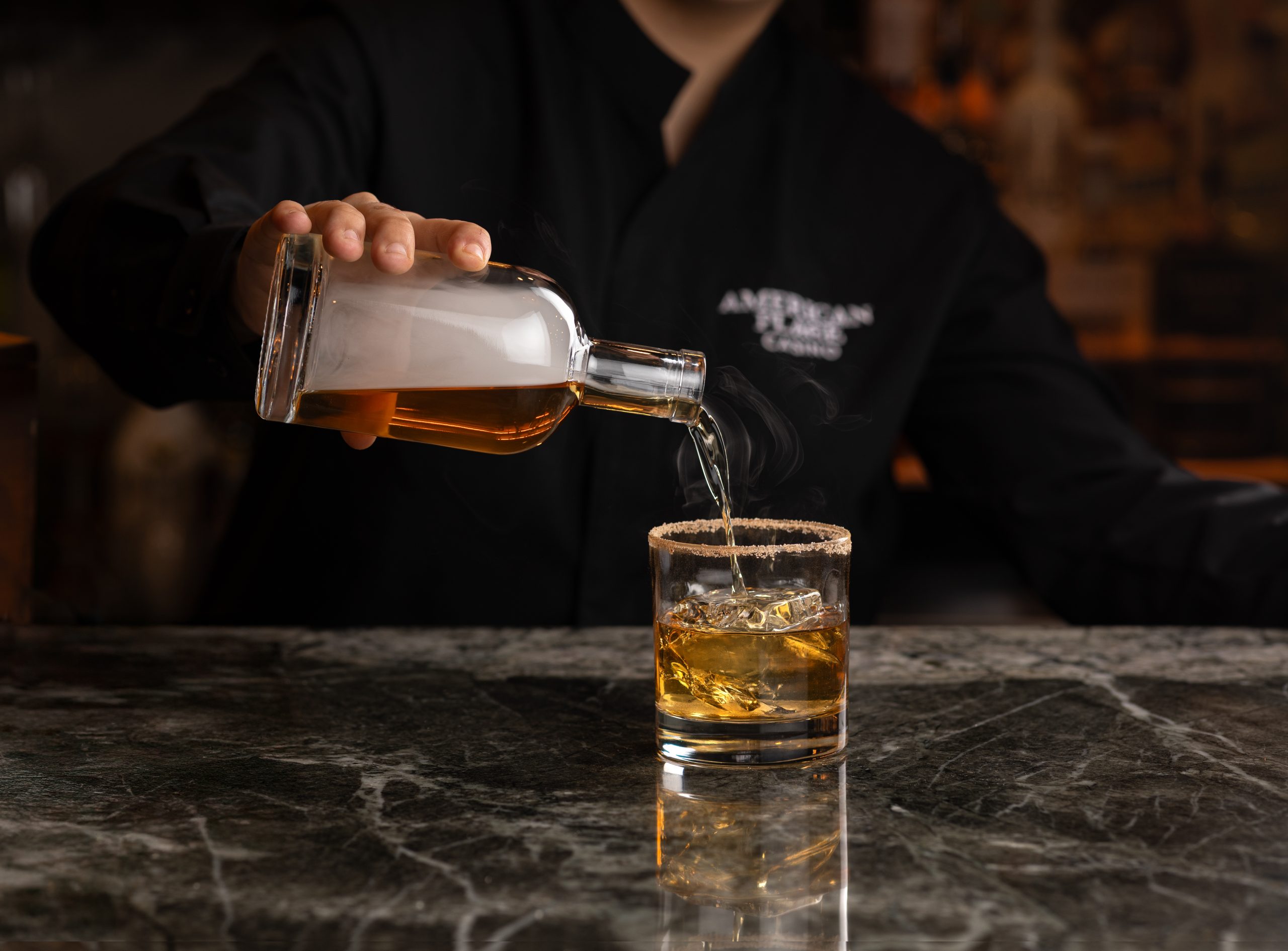 Person pouring whiskey into a glass at a Waukegan bar.
